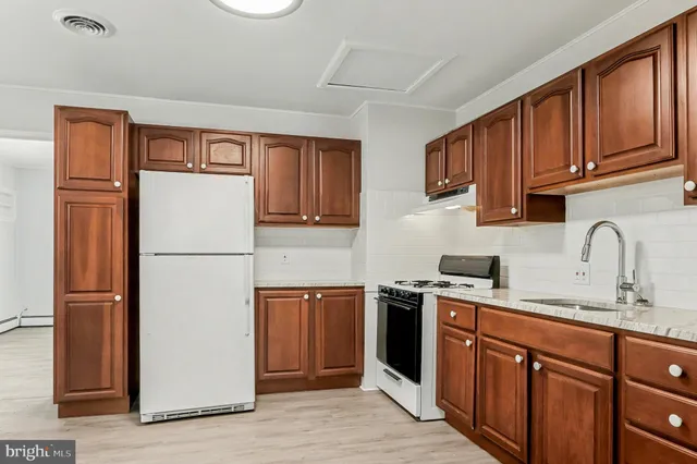 a kitchen with stainless steel appliances granite countertop a refrigerator sink and cabinets