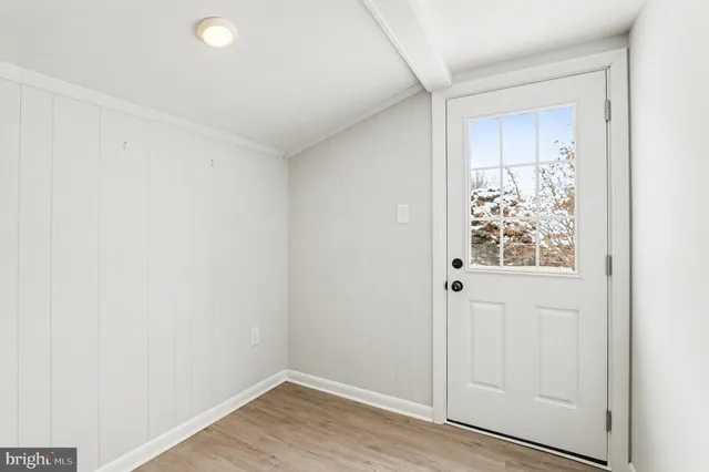 a view of a room with wooden floor and mirror