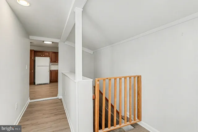 a view of a hallway with wooden floor and staircase