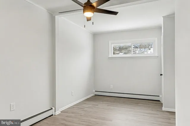 an empty room with a ceiling fan and wooden floor