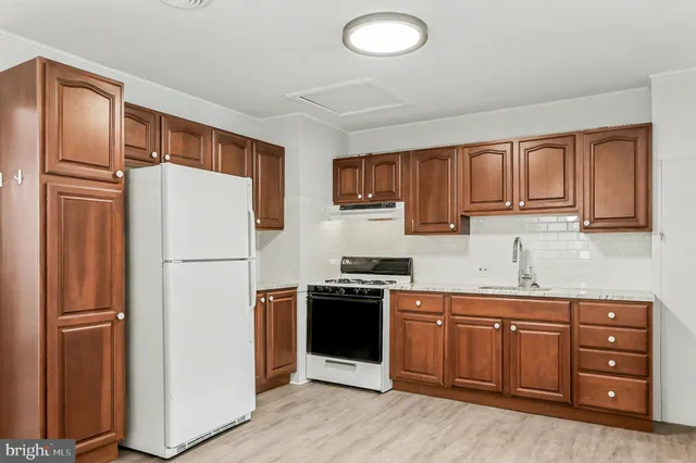 a kitchen with a refrigerator sink stove and cabinets