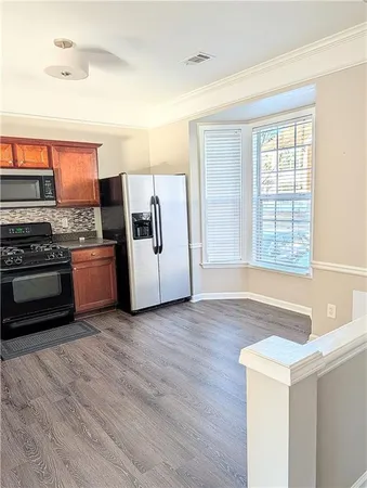 a kitchen with stainless steel appliances granite countertop a stove a sink and a refrigerator