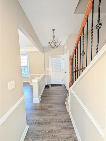 a view of a hallway with wooden floor and staircase