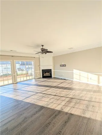 a view of empty room with wooden floor and window