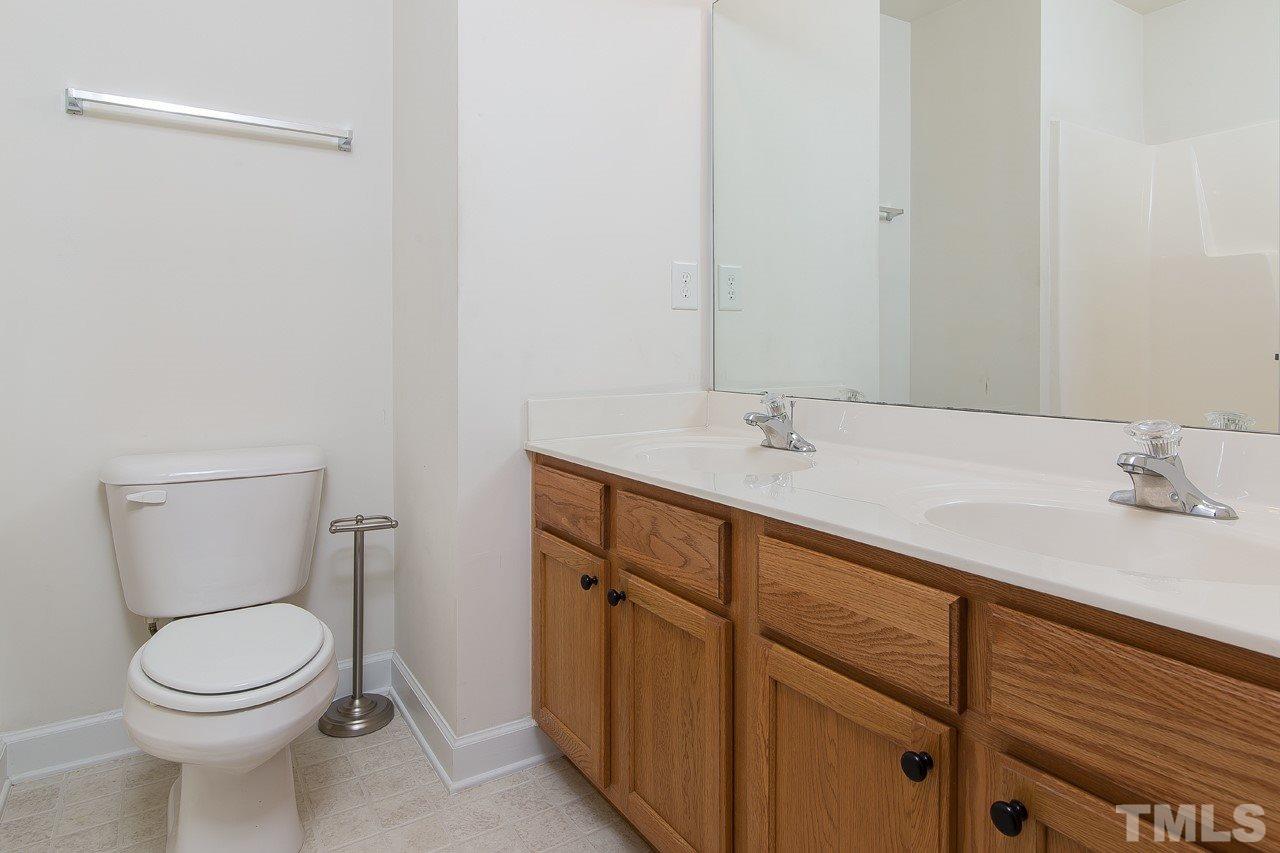 707 Turmeric Lane Durham, NC 27713 - Photo 16 of 18 a bathroom with a toilet sink and mirror
