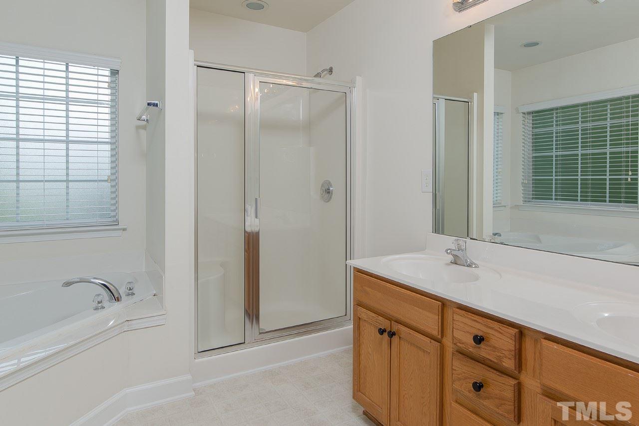 707 Turmeric Lane Durham, NC 27713 - Photo 10 of 18 a spacious bathroom with a granite countertop sink and a bathtub