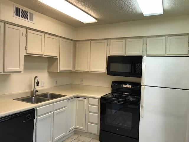 4748 Old Bent Tree Lane, Unit 803 Dallas, TX 75287 - Photo 5 of 20 a kitchen with a sink and a refrigerator
