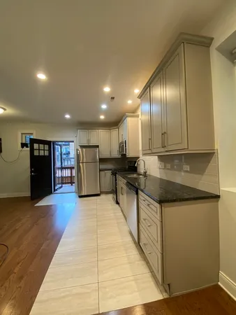 a kitchen with stainless steel appliances granite countertop wooden cabinets a granite counter tops and a fireplace