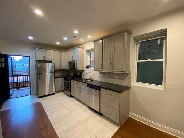 a kitchen with stainless steel appliances granite countertop a refrigerator and a sink