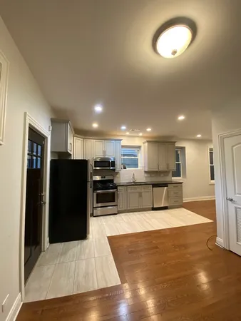 a view of kitchen with stainless steel appliances kitchen island granite countertop a refrigerator and a stove top oven