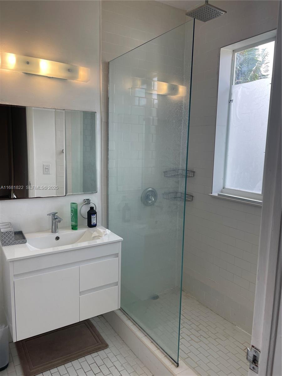 3921 Meridian Avenue Miami Beach, FL 33140 - Photo 23 of 29 a bathroom with a double vanity sink a mirror and shower