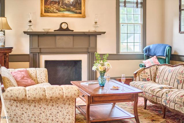 a kitchen with stainless steel appliances granite countertop a refrigerator a sink dishwasher a stove and a dining table with wooden floor