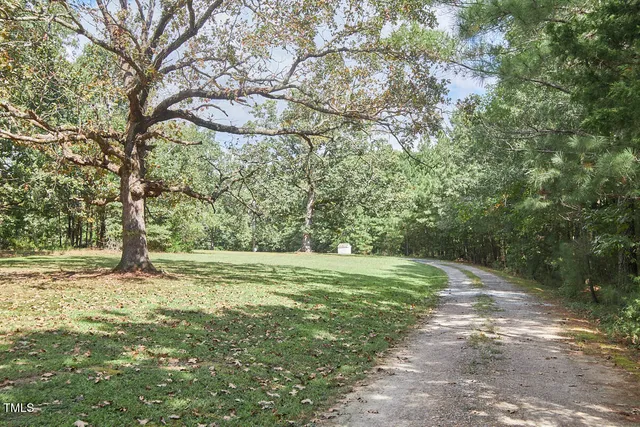 a front view of house with yard and trees around