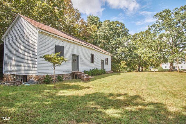 a view of backyard with large trees and plants