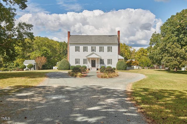 a view of a chair and table in backyard of the house