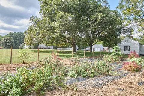 an aerial view of residential houses with outdoor space and trees