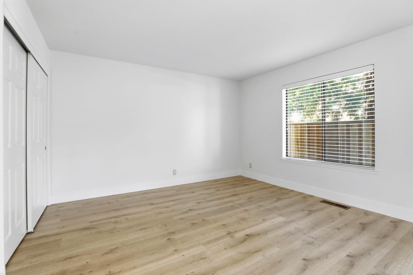 1555 Hecker Pass Road, Unit H102 Gilroy, CA 95020 - Photo 9 of 34 a view of an empty room with wooden floor and a window