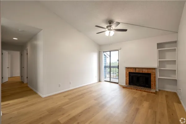 wooden floor fireplace and windows in an empty room