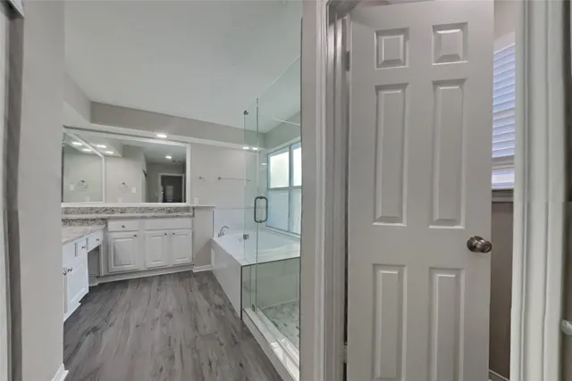 a large bathroom with a glass door shower sink and mirror