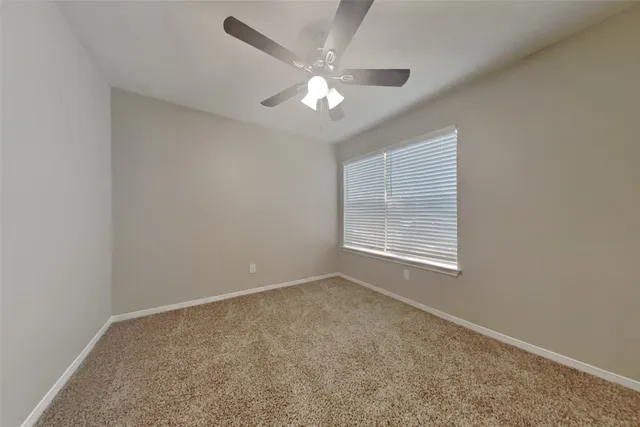a view of a livingroom with a ceiling fan and window