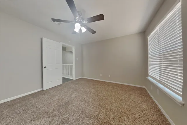 en empty room with windows and fan