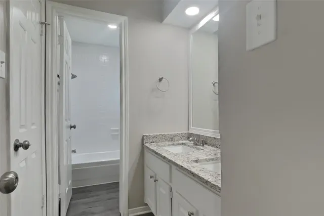 a bathroom with a granite countertop sink and a mirror