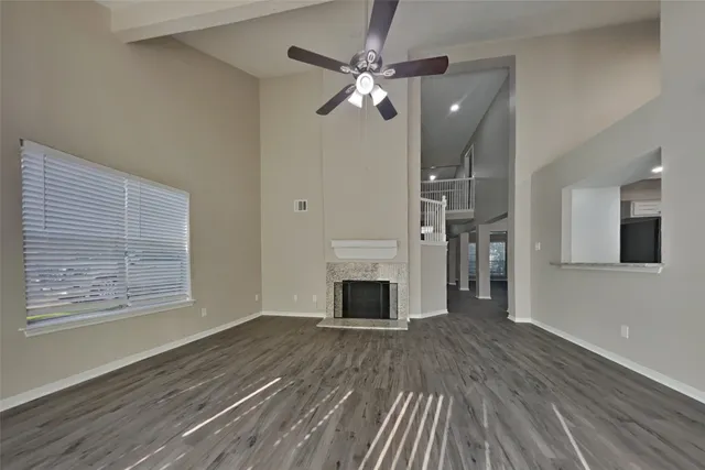 wooden floor fireplace and windows in an empty room