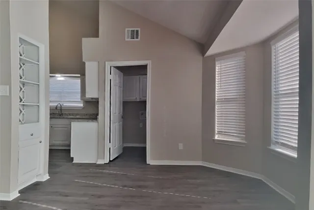 a view of a kitchen with refrigerator and window