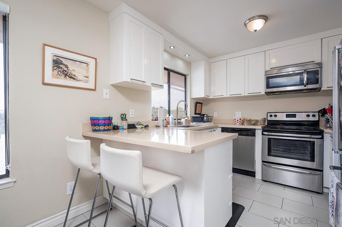 4266 Sixth Avenue San Diego, CA 92103 - Photo 11 of 29 a kitchen with stainless steel appliances a stove a sink cabinets and a dining table