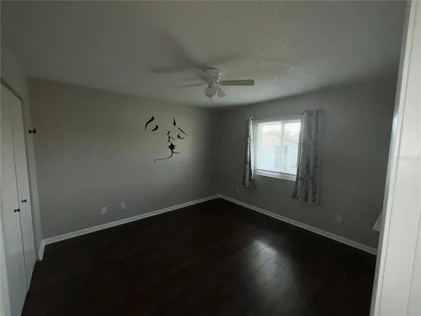 an empty room with a window and wooden floor