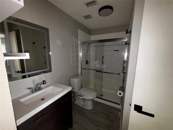 a bathroom with a sink mirror toilet and shower