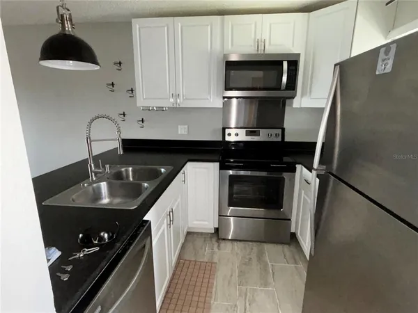a kitchen with a sink appliances and cabinets