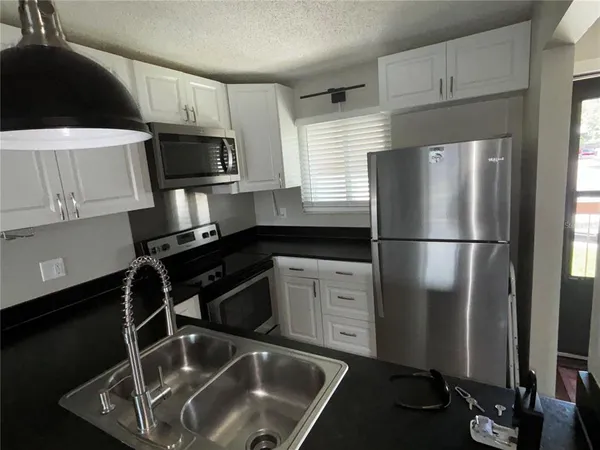 a kitchen with a refrigerator sink and microwave