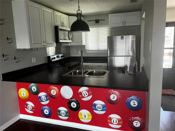 a kitchen with stainless steel appliances a sink a stove and a refrigerator