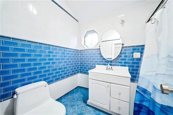 a bathroom with a sink mirror and toilet