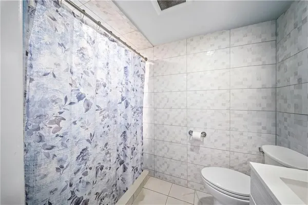 a bathroom with a toilet and a shower curtain