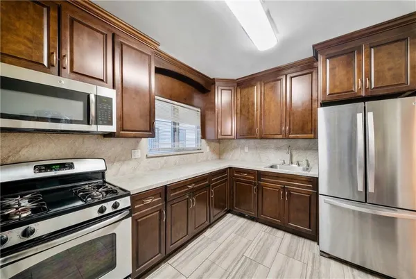 a kitchen with stainless steel appliances granite countertop a refrigerator stove top oven and sink