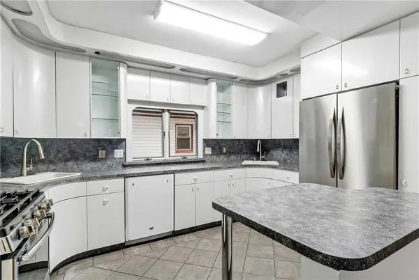 a kitchen with stainless steel appliances granite countertop a sink a stove and a refrigerator