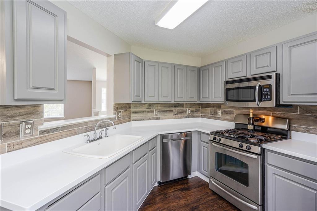 3272 Peach Court Acworth, GA 30101 - Photo 14 of 52 a kitchen with stainless steel appliances granite countertop a sink stove a microwave and cabinets