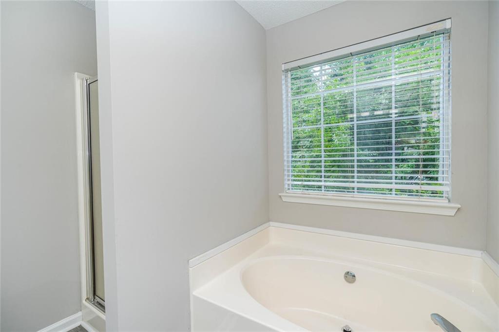 3272 Peach Court Acworth, GA 30101 - Photo 22 of 52 a white bath tub sitting in a bathroom next to a window