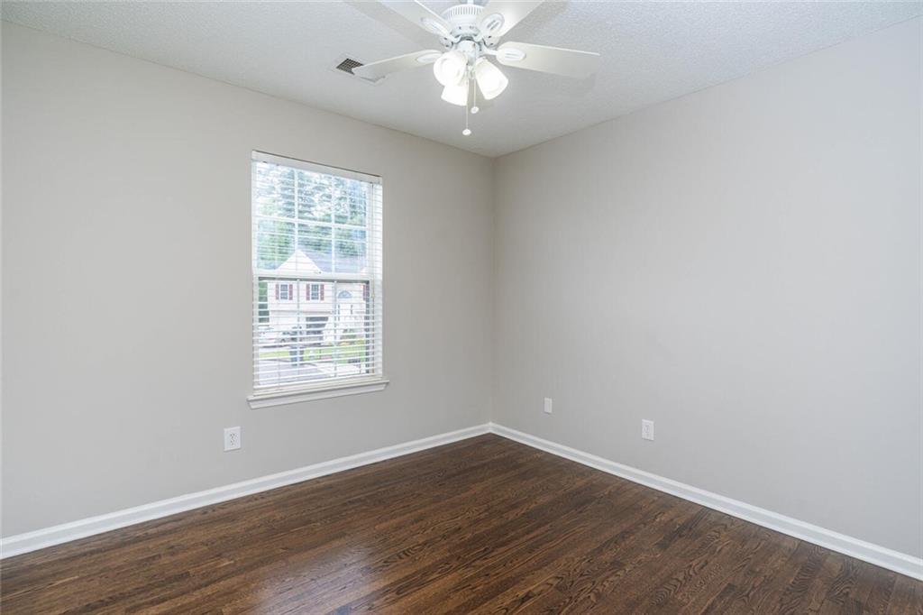 3272 Peach Court Acworth, GA 30101 - Photo 29 of 52 an empty room with wooden floor chandelier fan and windows