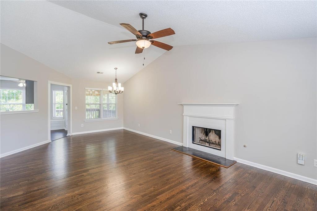 3272 Peach Court Acworth, GA 30101 - Photo 8 of 52 an empty room with wooden floor fireplace and windows