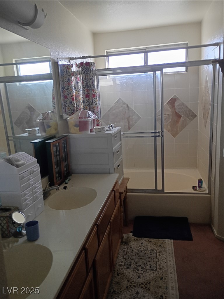 934 Derringer Lane Henderson, NV 89014 - Photo 41 of 49 Bathroom featuring double vanity, enclosed tub / shower combo, and healthy amount of natural light