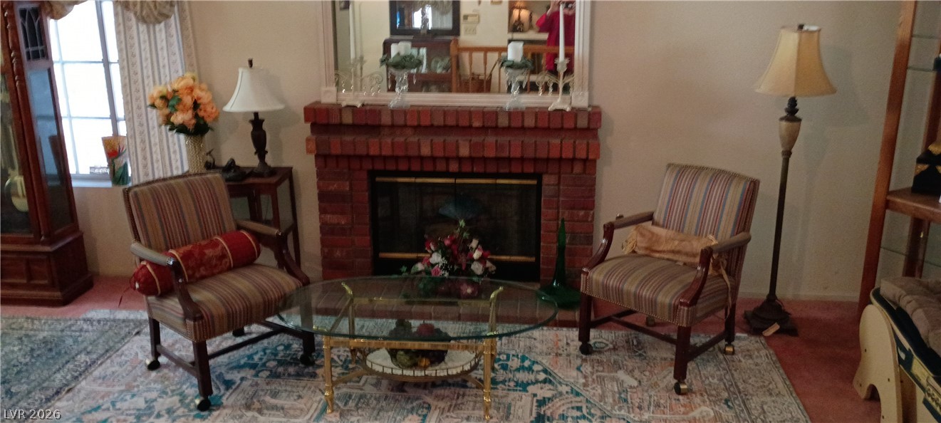 934 Derringer Lane Henderson, NV 89014 - Photo 8 of 49 living room featuring a brick fireplace and carpet floors