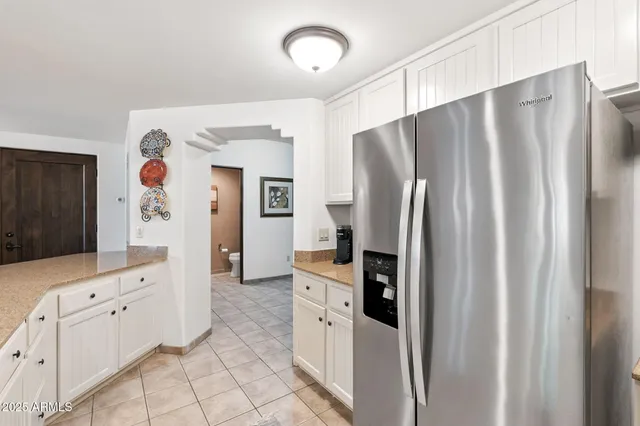 a kitchen with white cabinets and sink