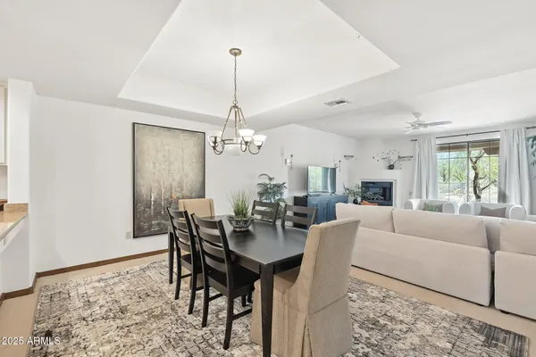 a dining room filled chandelier and kitchen view