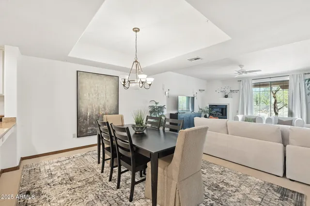 a dining room filled chandelier and kitchen view