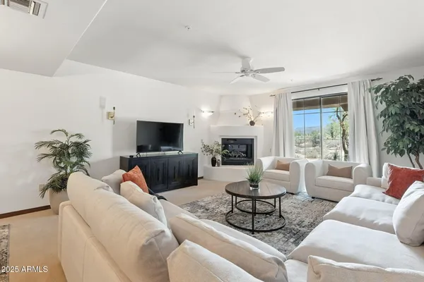 a living room with furniture and a view of kitchen