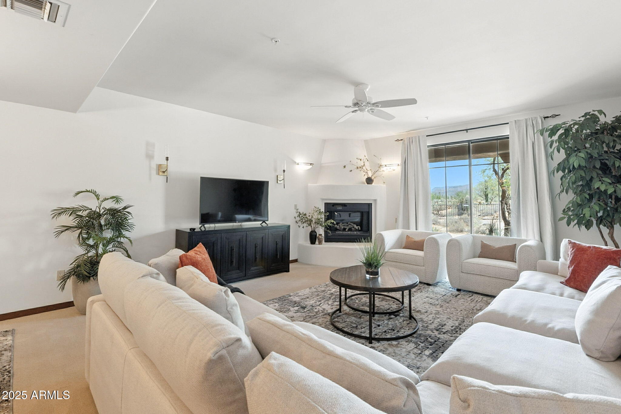 36601 North Mule Train Road, Unit B19 Carefree, AZ 85377 - Photo 25 of 53 a living room with furniture a flat screen tv and a fireplace