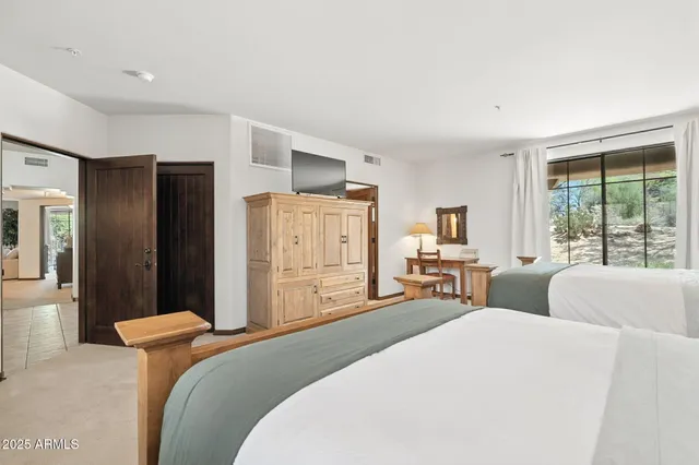 a bedroom with two beds and window